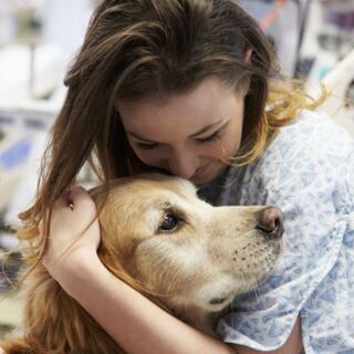 Woman embracing a golden retriever psychiatric service dog