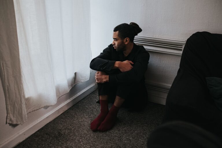 What are service dogs forBorderline Personality Disorder. A man kneeling in a bedroom corner.